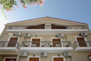 un edificio con balcones y sillas. en Papadatos Studios, en Argostoli