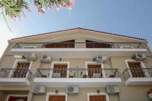 a building with balconies and chairs on it at Papadatos Studios in Argostoli