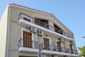 a tall white building with balconies on it at Papadatos Studios in Argostoli
