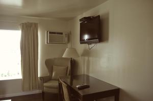 a room with a table and a chair and a television at Spindrift Motel in Ocean City