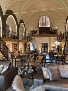 a lobby with couches and tables in a building at KerkHotel Biervliet in Biervliet