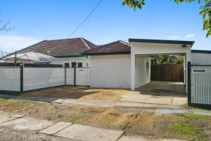 a house with a garage and a fence at Benson House & Benson Lodge in Benalla