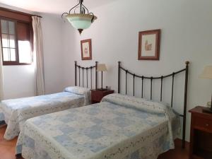 2 camas en un dormitorio con paredes blancas en Apartamentos Cádiz el Chico, en Grazalema