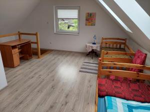 a attic room with a bunk bed and a desk at Domek przy Puszczy Białowieskiej in Dubiny