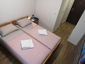 a bedroom with a bed with two white towels on it at Apartman 25 in Belgrade