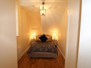 - une chambre avec un lit et deux lampes de chaque côté dans l'établissement Garda House, à Kinsale