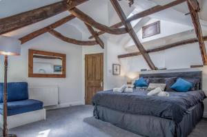 1 dormitorio con 1 cama azul y 1 silla azul en White Mill - 4 Bedroom Holiday Home - Lampeter Velfrey - Narberth, en Lampeter-Velfrey