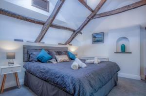 1 dormitorio con 1 cama grande con almohadas azules en White Mill - 4 Bedroom Holiday Home - Lampeter Velfrey - Narberth, en Lampeter-Velfrey