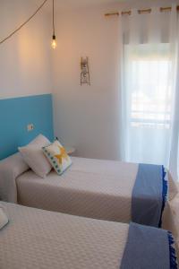 1 dormitorio con 2 camas y ventana en H El Palmeral Playa, en Mojácar