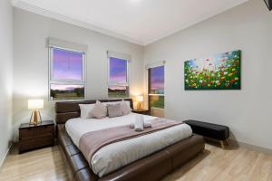 1 dormitorio con 1 cama y una pintura en la pared en Loemans Lodge, 5 Bedrooms near Airport, Free Parking, en Bulla