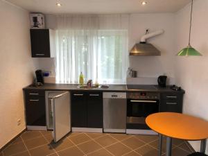 a kitchen with a sink and a counter with a table at Hotel Saarland Lebach in Lebach