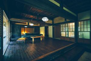 a living room with a couch and a table at Kominkayado LOOF Sannoie in Koike