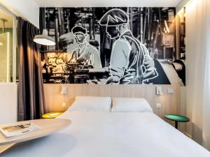 a bedroom with a bed and a black and white photo at ibis Styles Limoges Centre in Limoges