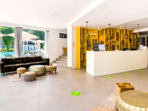 a living room with yellow cabinets and a couch at ibis Styles Golden Sands Roomer Hotel in Golden Sands