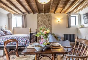 een kamer met een tafel en stoelen en een bed bij Loaf in Bridport