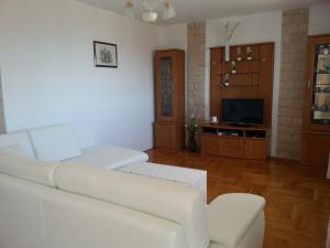 a living room with a white couch and a tv at Villa Mikrut in Podstrana