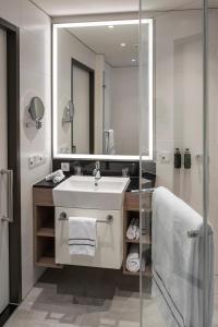 a bathroom with a sink and a mirror at Meliá Frankfurt City in Frankfurt/Main