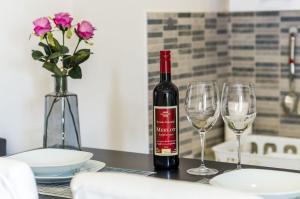 eine Flasche Wein auf einem Tisch mit zwei Gläsern in der Unterkunft Apartments Monica in Dubrovnik
