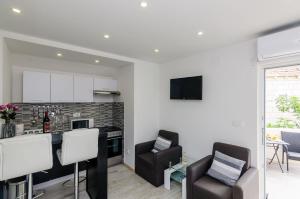 a kitchen and living room with two chairs and a counter at Apartments Monica in Dubrovnik