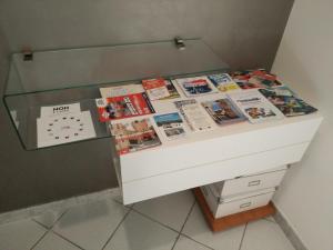 - une commode avec des livres et des magazines dans l'établissement Residenza Re Umberto, à Civitanova Marche