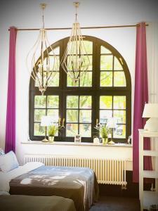 a bedroom with a large window with purple curtains at Sleephotels Suite Garde in Hamburg