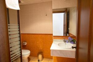 łazienka z umywalką, toaletą i lustrem w obiekcie Hostal Rural Zahara w mieście Zahara de la Sierra