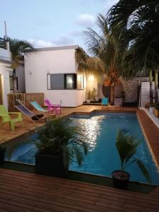 una piscina en el patio trasero de una casa con palmeras en Villa canne à sucre, en Saint-Louis