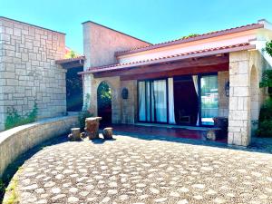 uma casa com um pátio de pedra em frente em Finca Briabí em La Cañiza