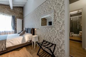 a bedroom with a bed and a mirror on a wall at Relais la Fornarina in Rome
