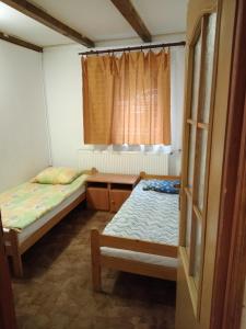 a small room with two beds and a window at aura in Suwałki
