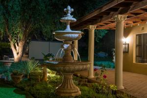 une grande fontaine au milieu d'un jardin dans l'établissement Toscana Estate, à Bloemfontein