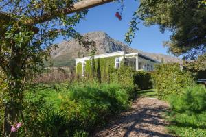 a house with a mountain in the background at Lily Pond House at Le Lude in Franschhoek