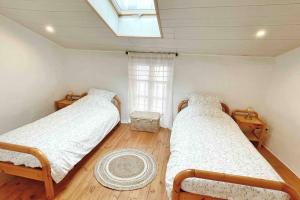 - 2 lits dans une chambre avec fenêtre dans l'établissement Gîte Chez Gabrielle, au Puy-en-Velay