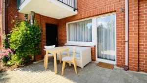 a table and chairs sitting next to a brick building at Pension Kühne in Boltenhagen