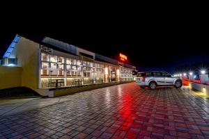 コールハープルにあるHotel Park Tree, Kolhapurの夜間の建物前に停車する車