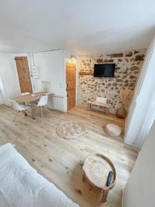 Cette chambre comprend un lit, une table et une télévision. dans l'établissement Gîte Chez Gabrielle, au Puy-en-Velay