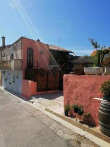 een huis met een rode muur naast een straat bij Stanza Del Viggiatore in Santadi
