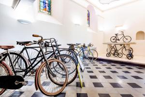 a row of bikes parked in a room with a checkered floor at Le Nesk Ventoux - Hotel in Sault-de-Vaucluse
