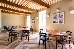 a dining room with wooden tables and chairs at Le Nesk Ventoux - Hotel in Sault-de-Vaucluse