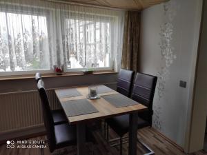 a dining room table with chairs and a window at Ferienwohnung Wicke in Thale