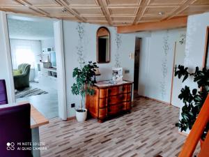 a living room with a dresser and plants in it at Ferienwohnung Wicke in Thale