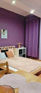 a bedroom with a bed with a purple wall at Jopi Hostel Katowice Centrum in Katowice