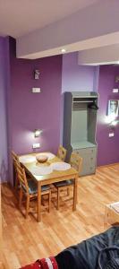 einen Tisch und Stühle in einem Zimmer mit einer lila Wand in der Unterkunft Jopi Hostel Katowice Centrum in Kattowitz