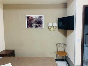 a room with a table and a television and a chair at Тетя Соня in Romny