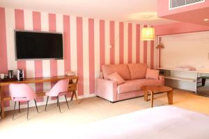 een woonkamer met een bank en een tafel bij Hotel Casarose - Cannes Mandelieu in Mandelieu-la-Napoule