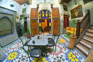 a room with a table and chairs and stairs at Riad Dar Fes in Fès