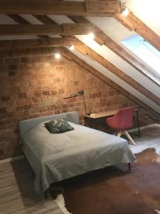 - une chambre avec un lit et un bureau dans un mur en briques dans l'établissement Martins Guesthouse Zimmer, à Hanovre