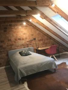 a bedroom with a bed and a desk in a brick wall at Martins Guesthouse Zimmer in Hannover