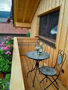 una mesa pequeña y 2 sillas en una terraza de madera en Ferienwohnung Fernweh, en Bolsterlang