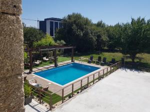 a large swimming pool with a wooden deck at Garden Place Alojamento Local in Viseu